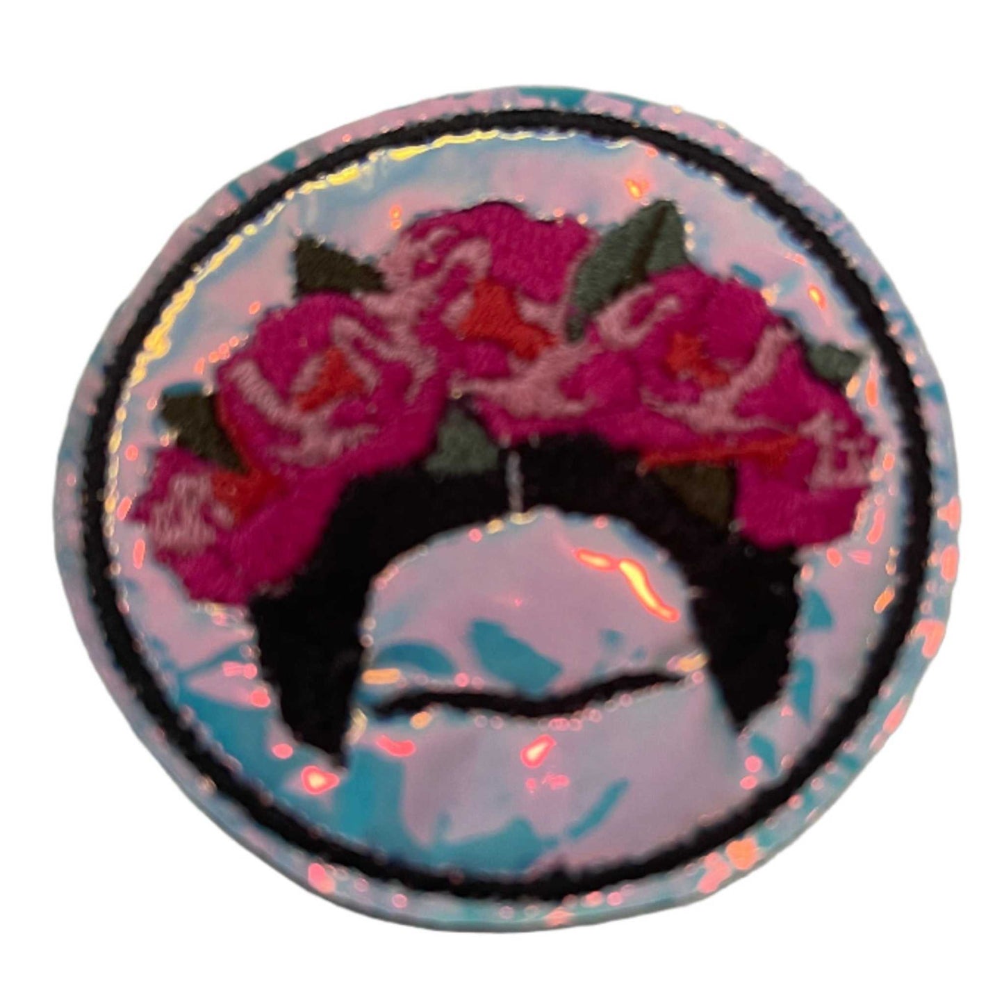 Frida Kahlo flower crown holographic vinyl patch with pink and vermillion flowers, aqua leaves, and black details.