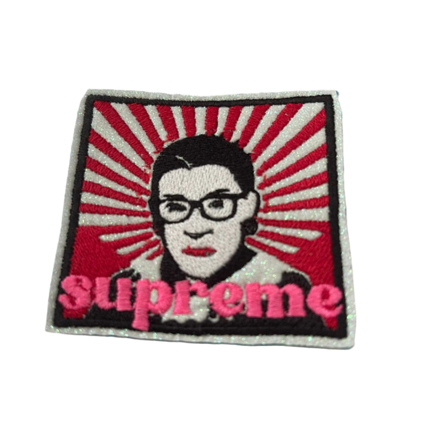 RBG Supreme patch with red rays, white glitter vinyl, black outline, and neon pink "supreme".