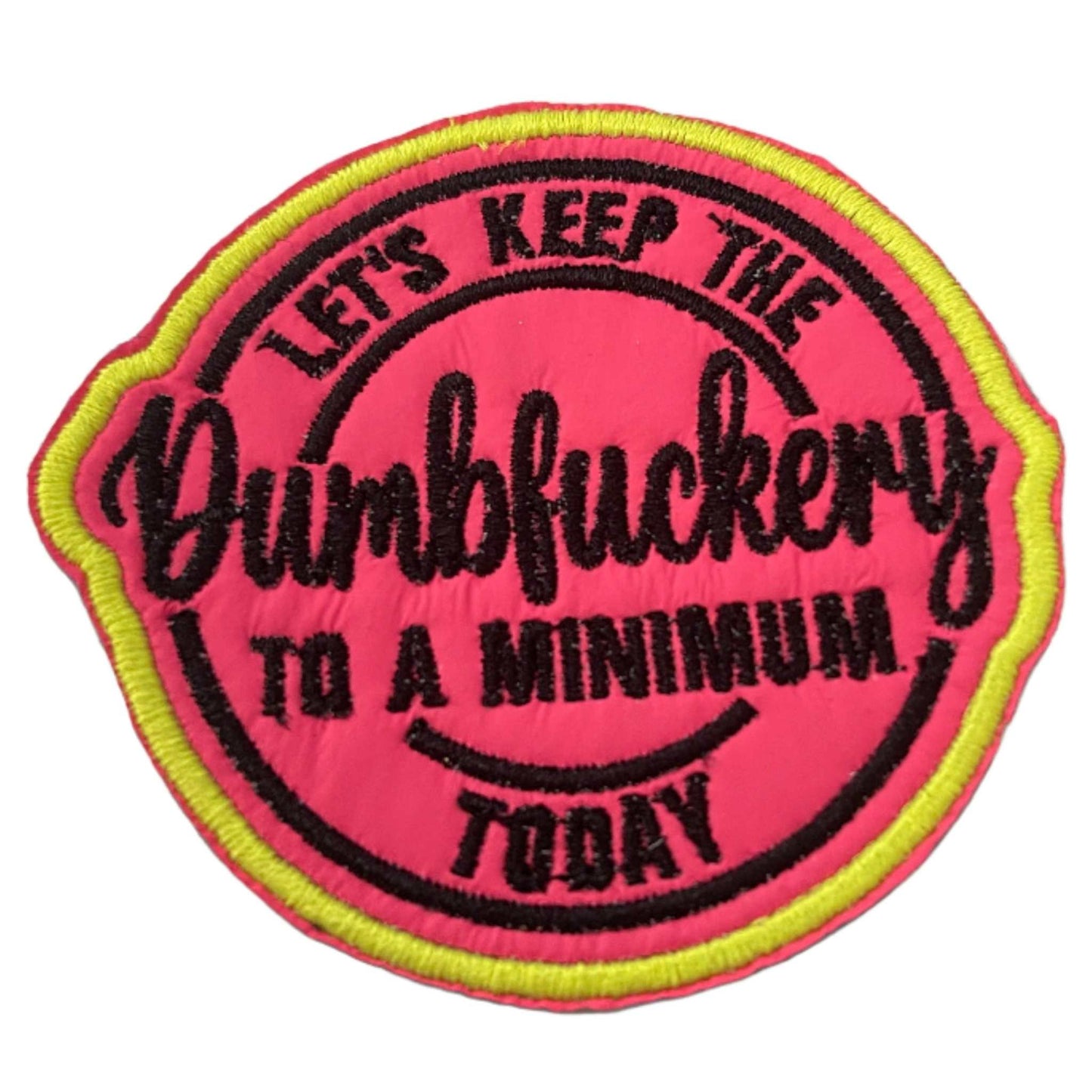 Round patch with "Dumbfuckery" in black text, neon pink background, and neon yellow outline.