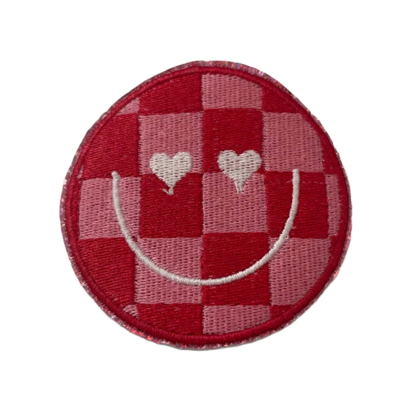 Checkerboard smiley face patch with heart eyes in red and pink.