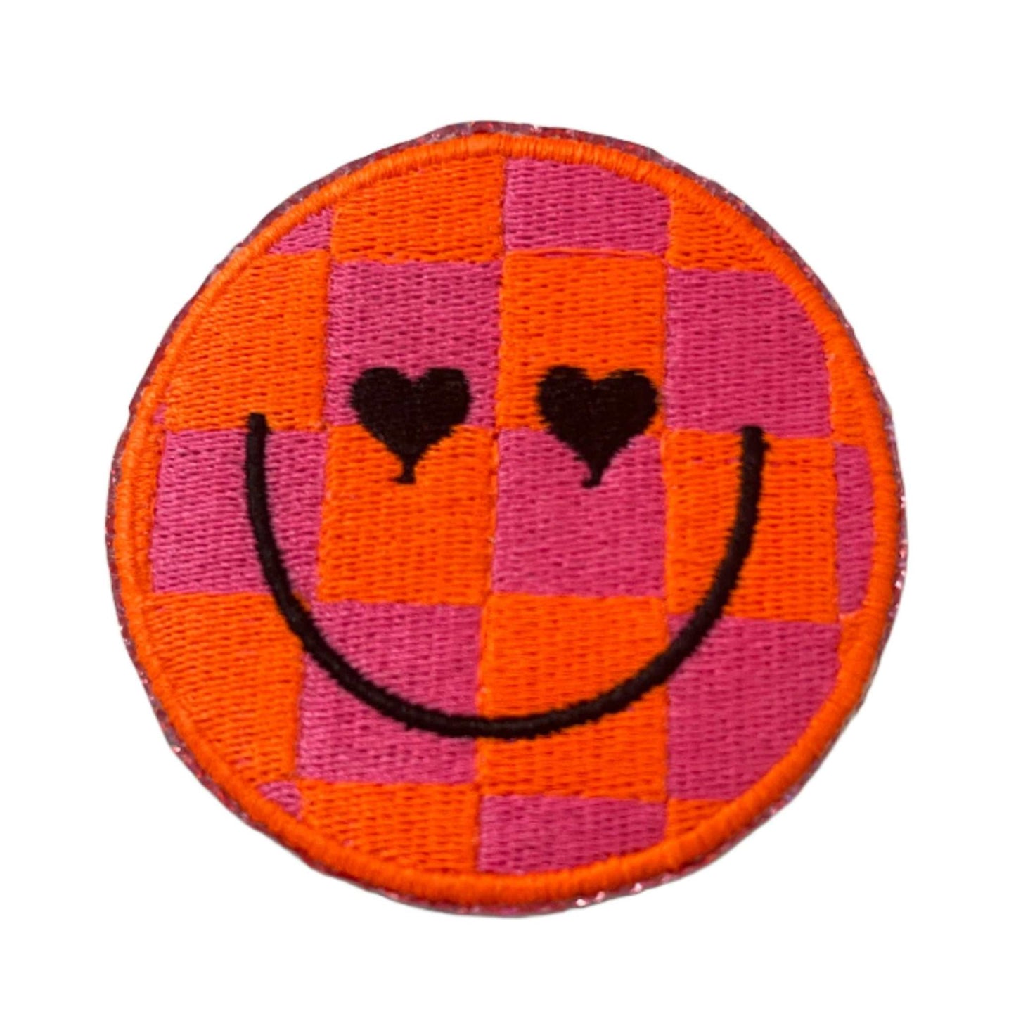 Checkerboard smiley face neon patch with heart eyes in neon orange and pink.