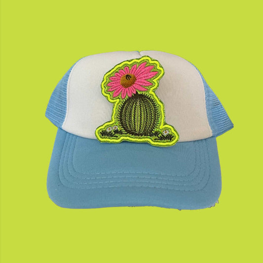 Iron-on patch featuring a green cactus with a vibrant pink flower, brown center, and neon yellow outline.