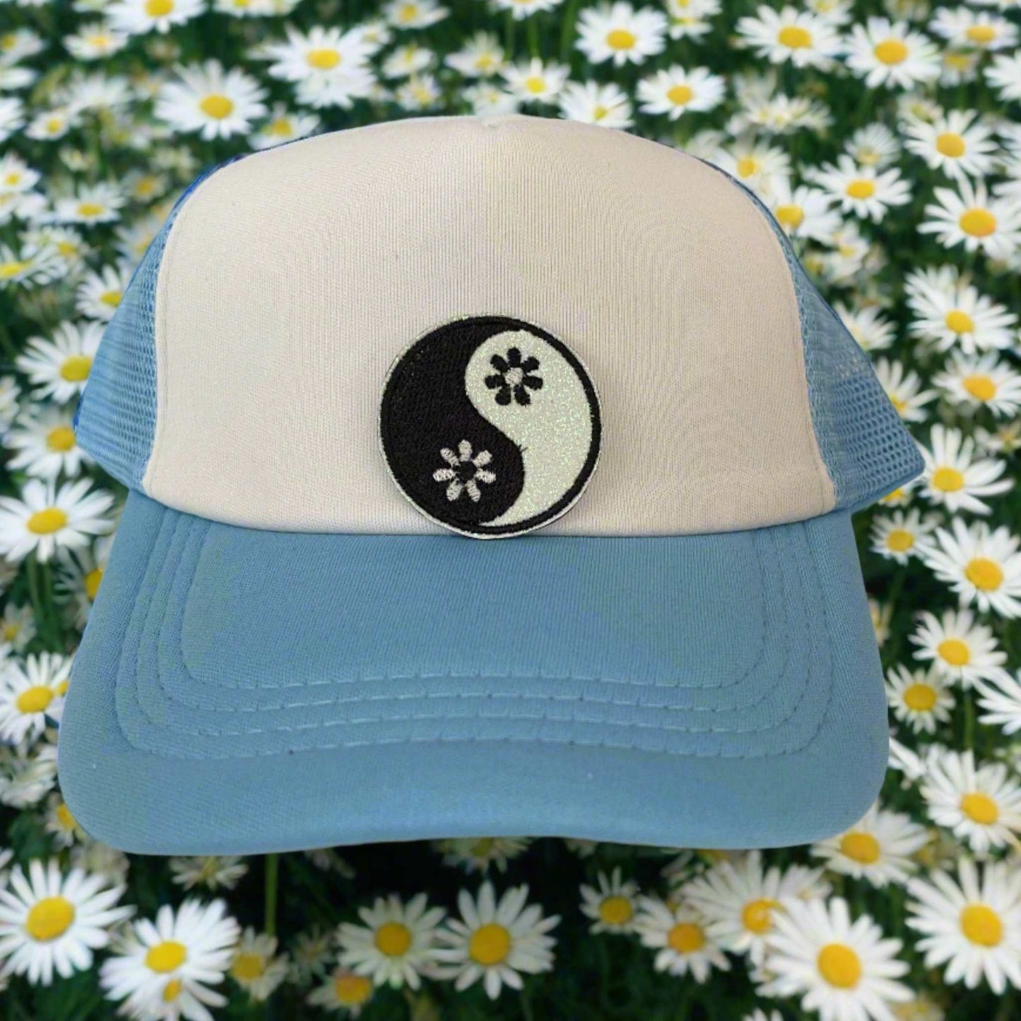 Close-up of a yin yang floral embroidered patch with black and white detailing, perfect for customizing hats and other accessories.
