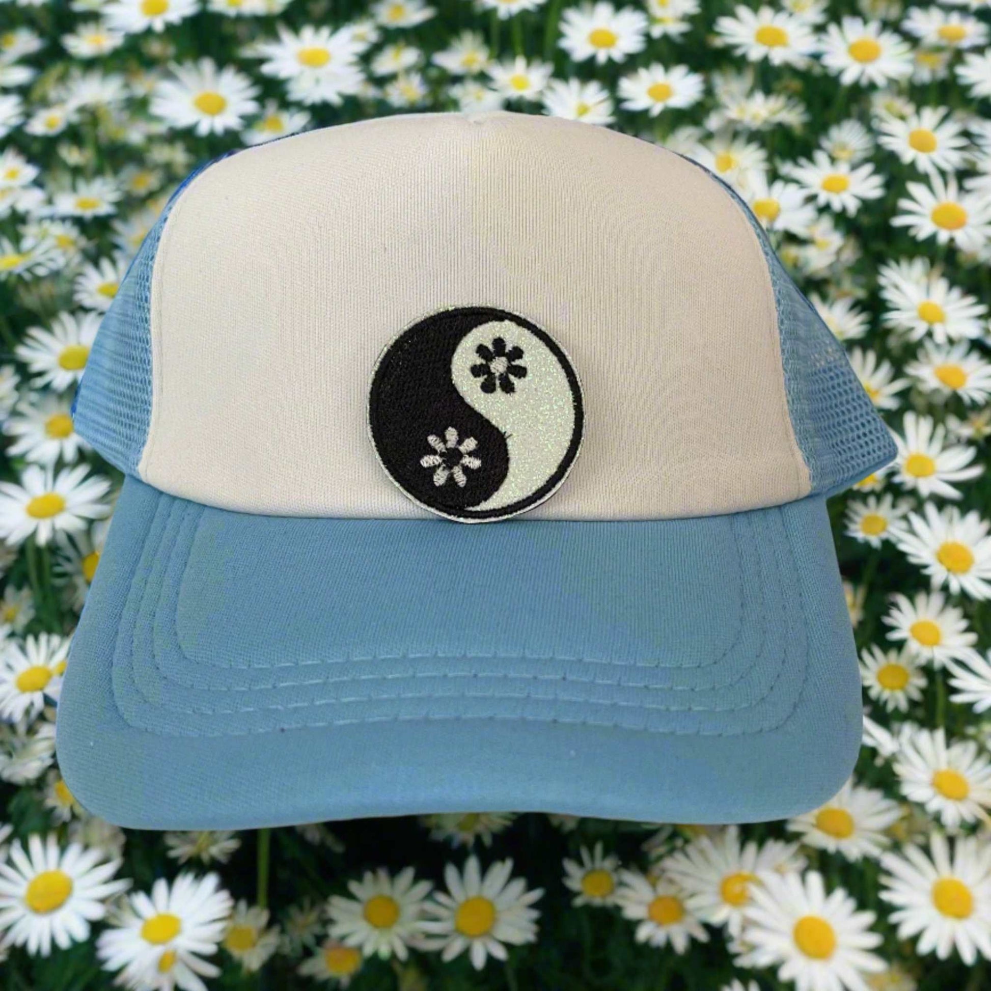 Close-up of a yin yang floral embroidered patch with black and white detailing, perfect for customizing hats and other accessories.