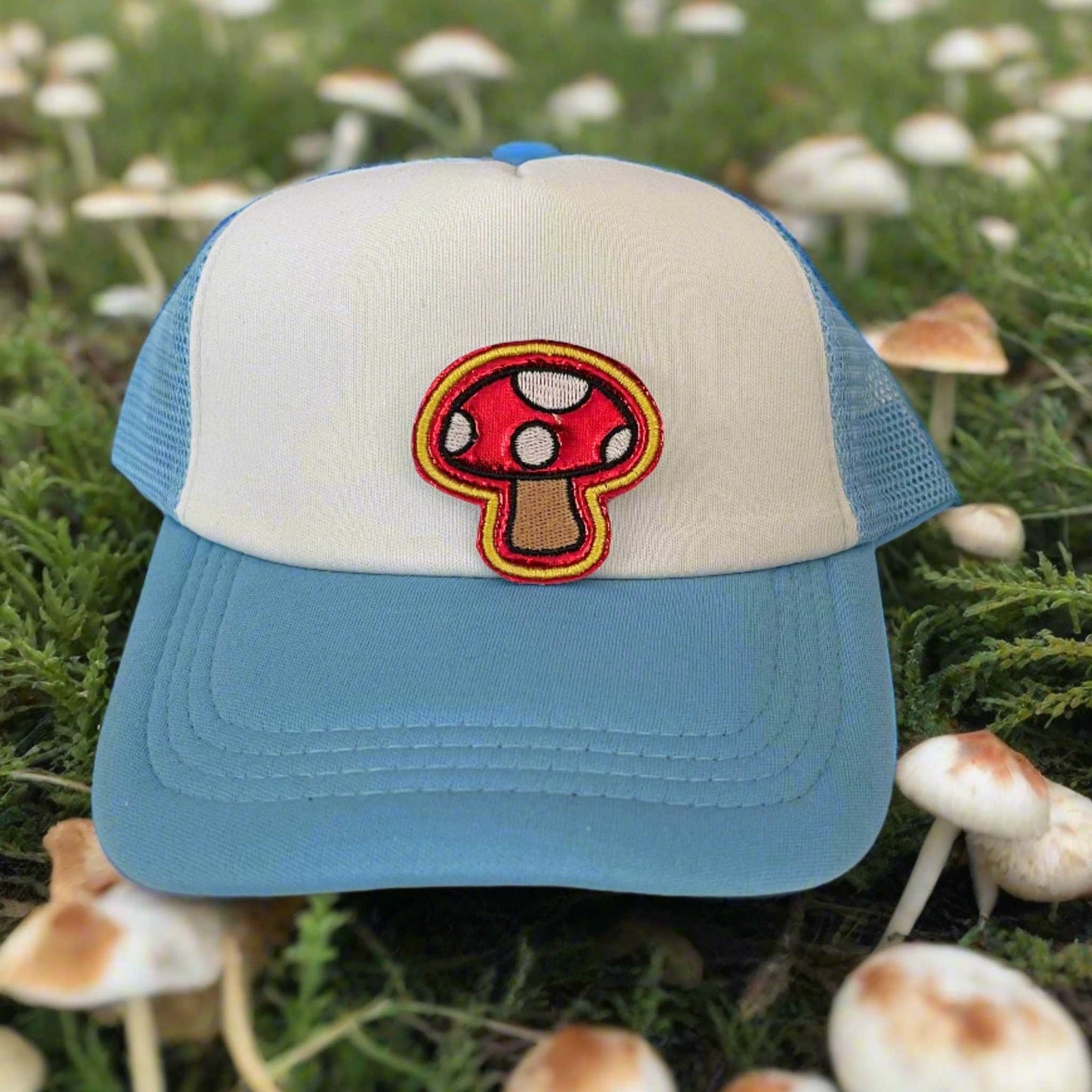 Close-up of a quirky mushroom embroidered patch with red and white detailing, perfect for customizing hats and other accessories.