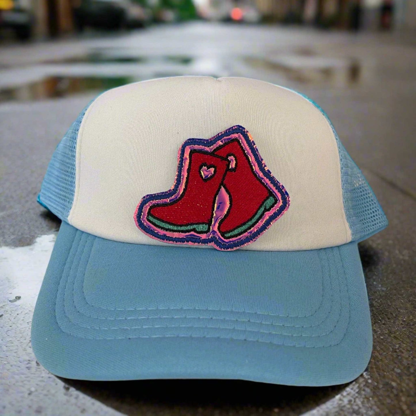Close-up of a colorful galoshes embroidered patch with red and pink detailing, perfect for customizing hats and other accessories.