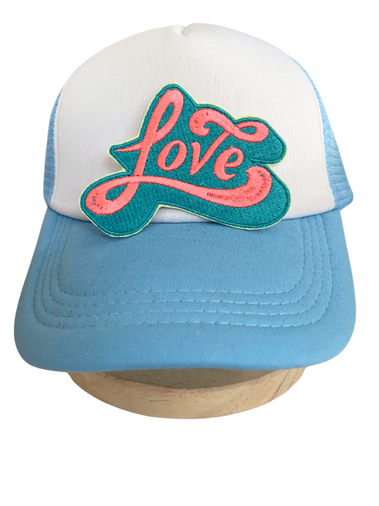 Close-up of embroidered "Love" patch in teal and pink colors.