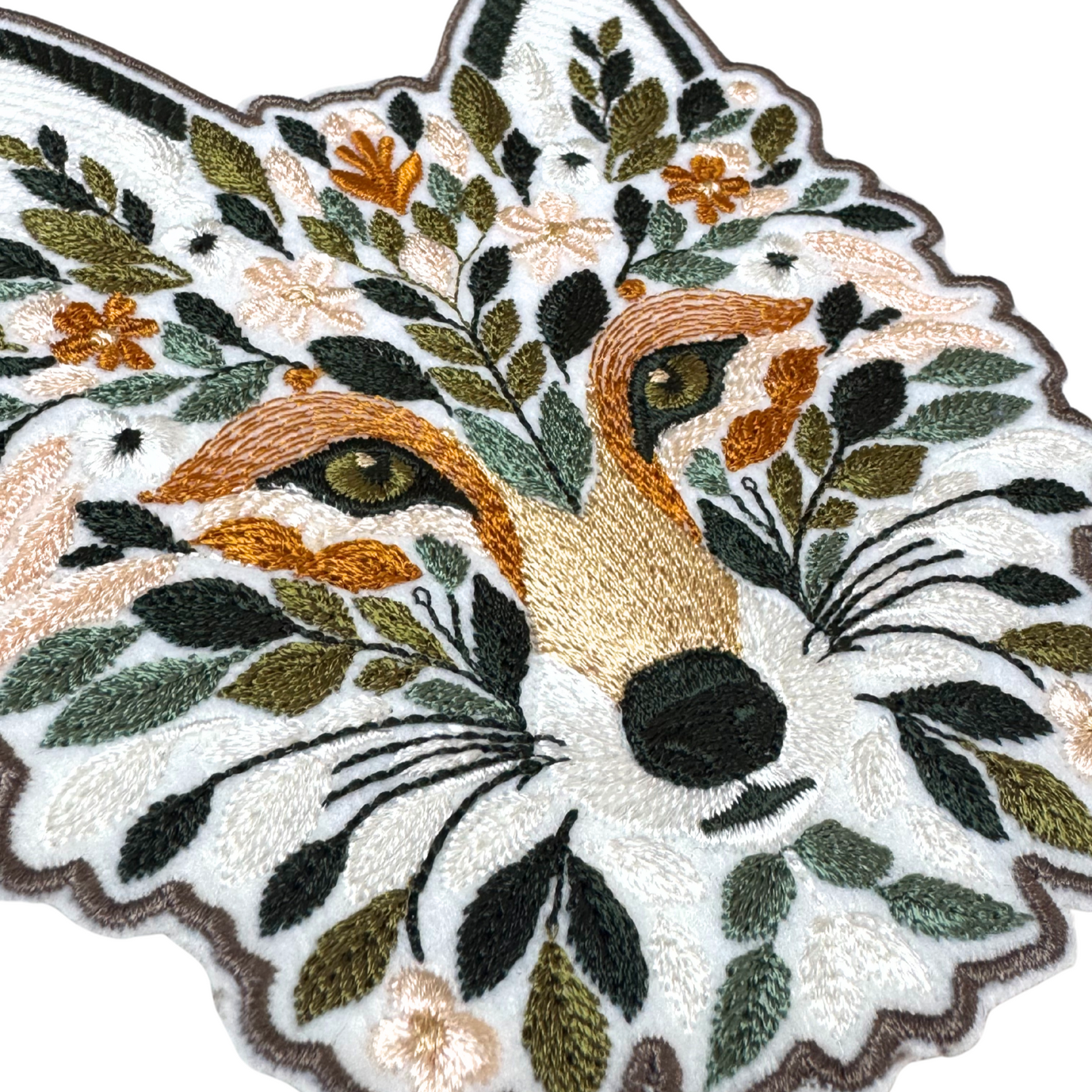 Side angle close-up of floral fox embroidered patch showing detailed stitches