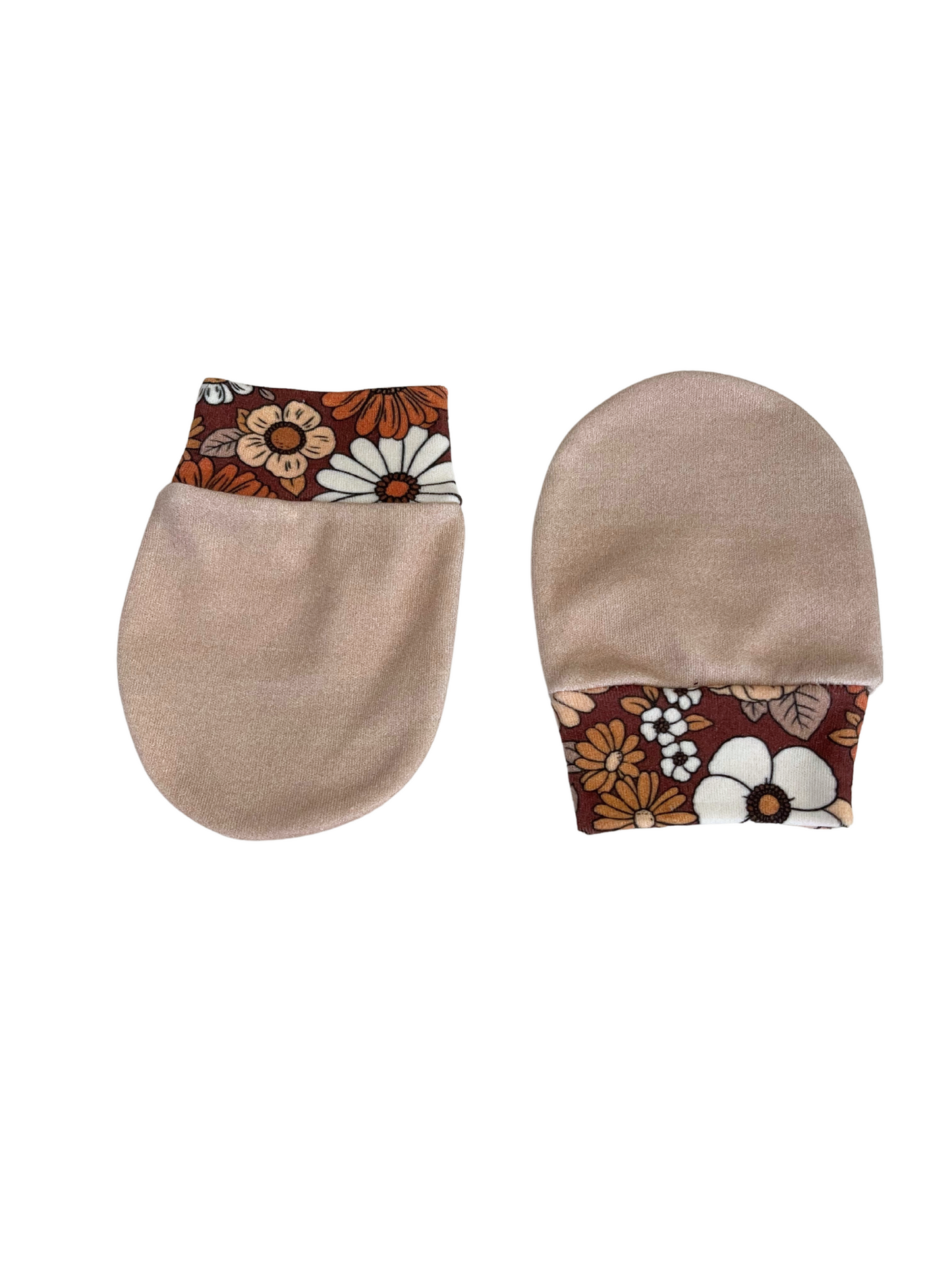 Baby scratch mittens with oatmeal-colored body and retro floral pattern cuffs in shades of brown, orange, and cream, made of organic cotton knit.