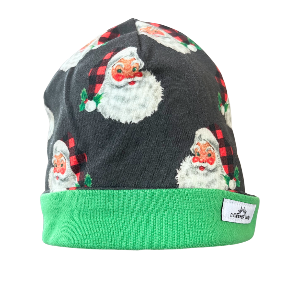 Handmade reversible organic cotton baby beanie with Santa print and green trim for 0-3 months.
