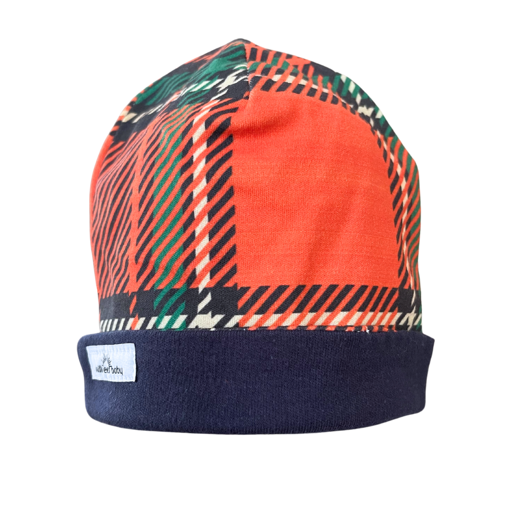 Handcrafted reversible organic cotton baby beanie with orange plaid and navy trim, perfect for 0-3 months.