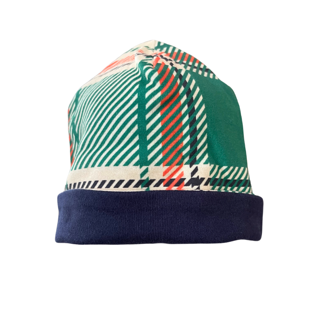 Handcrafted reversible organic cotton baby beanie in green plaid with navy trim, suitable for 0-3 months.