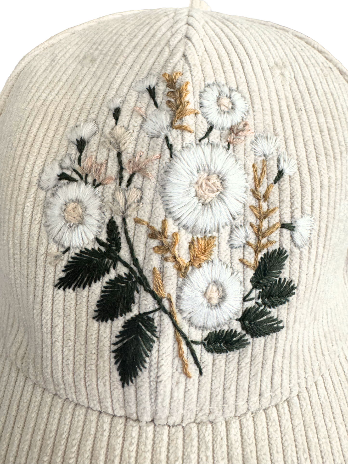 Hand-embroidered white floral design on ivory corduroy hat.