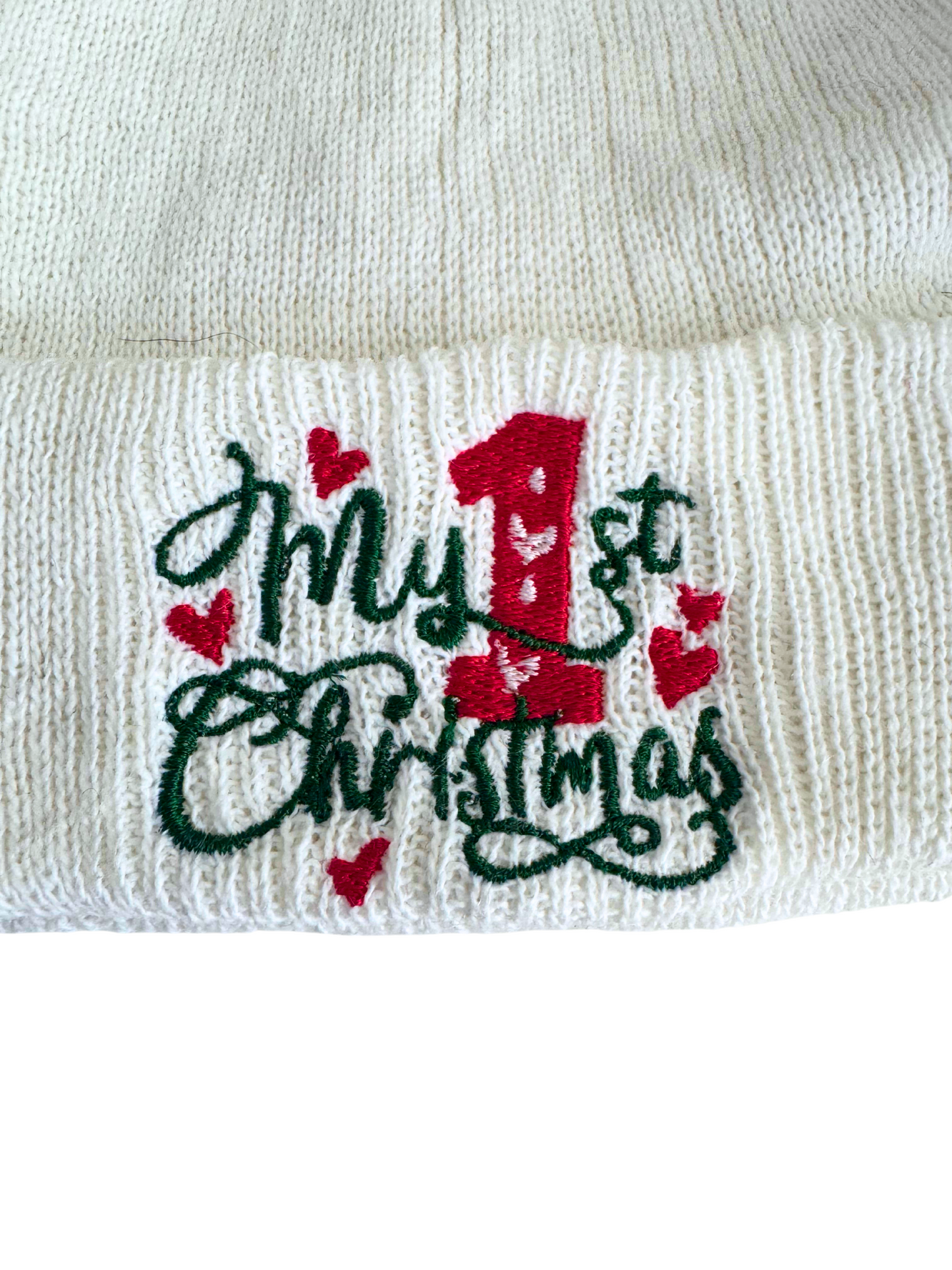 White baby beanie with "My 1st Christmas" embroidered in red and green, featuring red hearts.