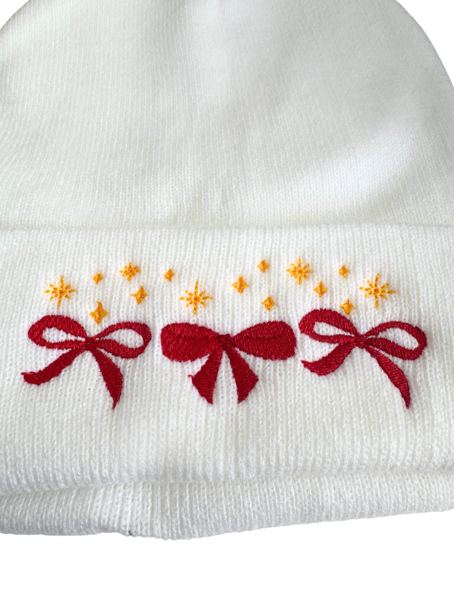 White beanie with red bows and golden star embroidery in Kansas City Chiefs colors.