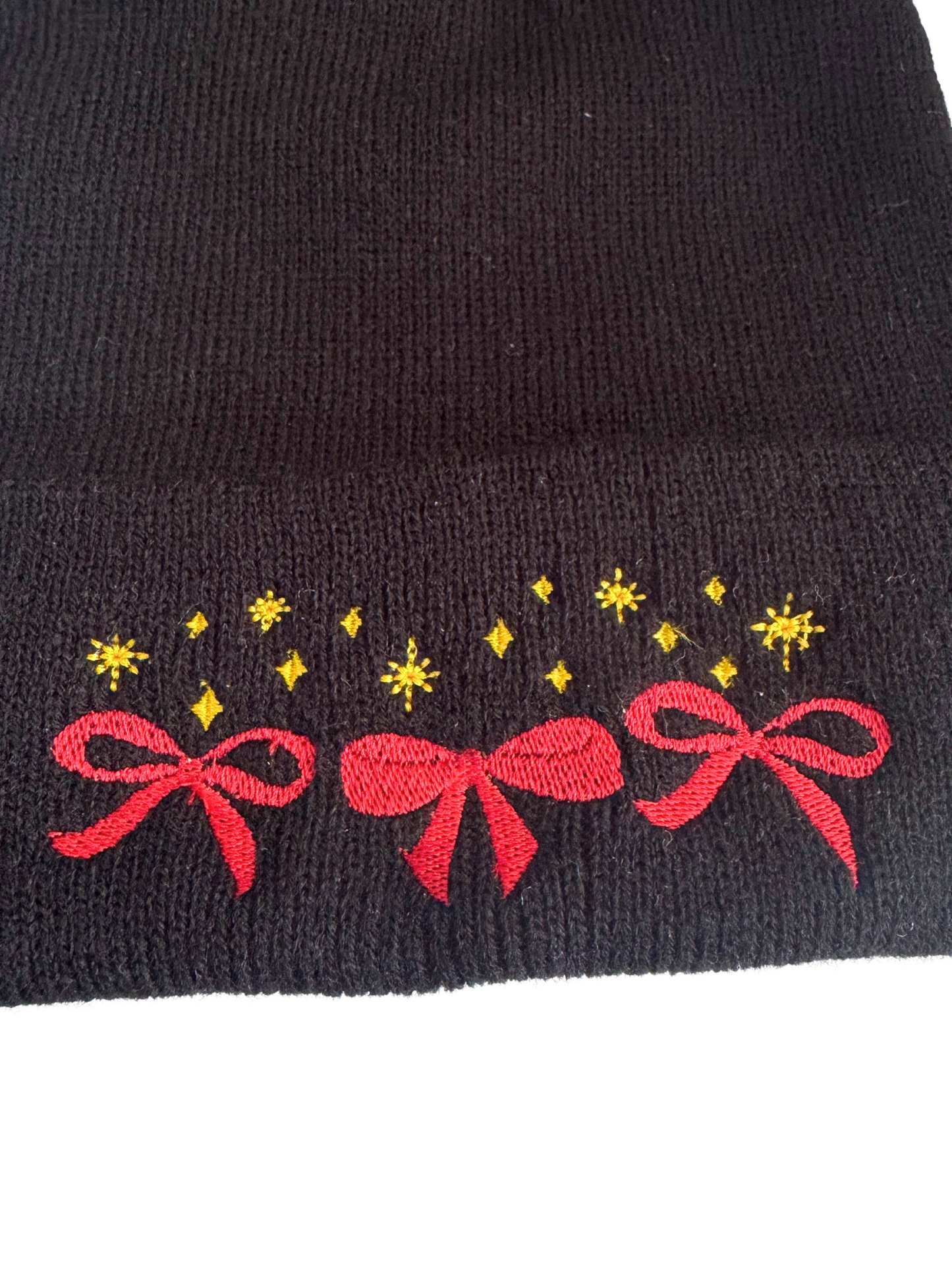 Black beanie with machine-embroidered red bows and golden stars in Chiefs colors.