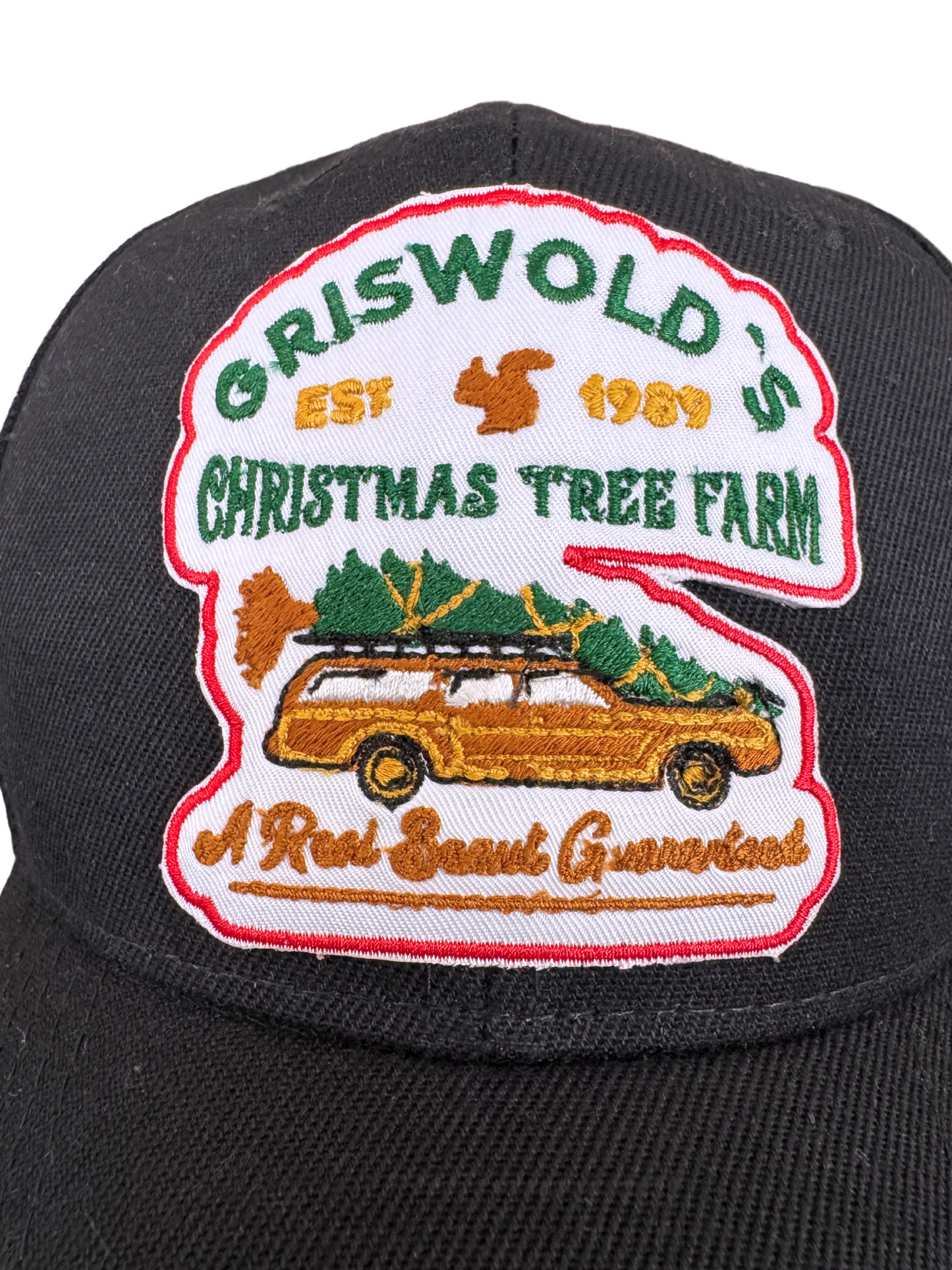 Griswold's Christmas Tree Farm black hat featuring an embroidered patch with a station wagon carrying a Christmas tree, inspired by National Lampoon’s Christmas Vacation.