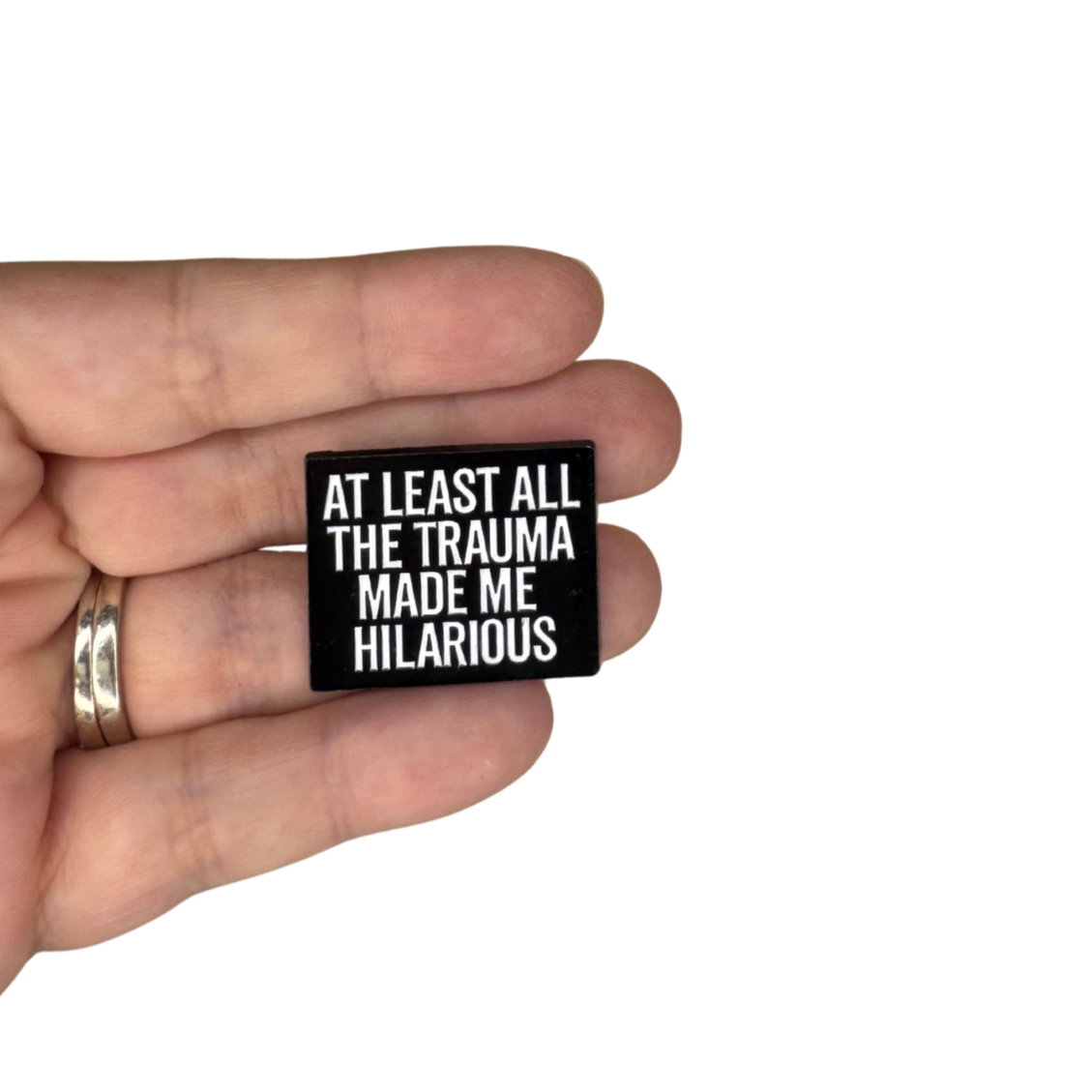 Scale photo of pin held in hand for size reference