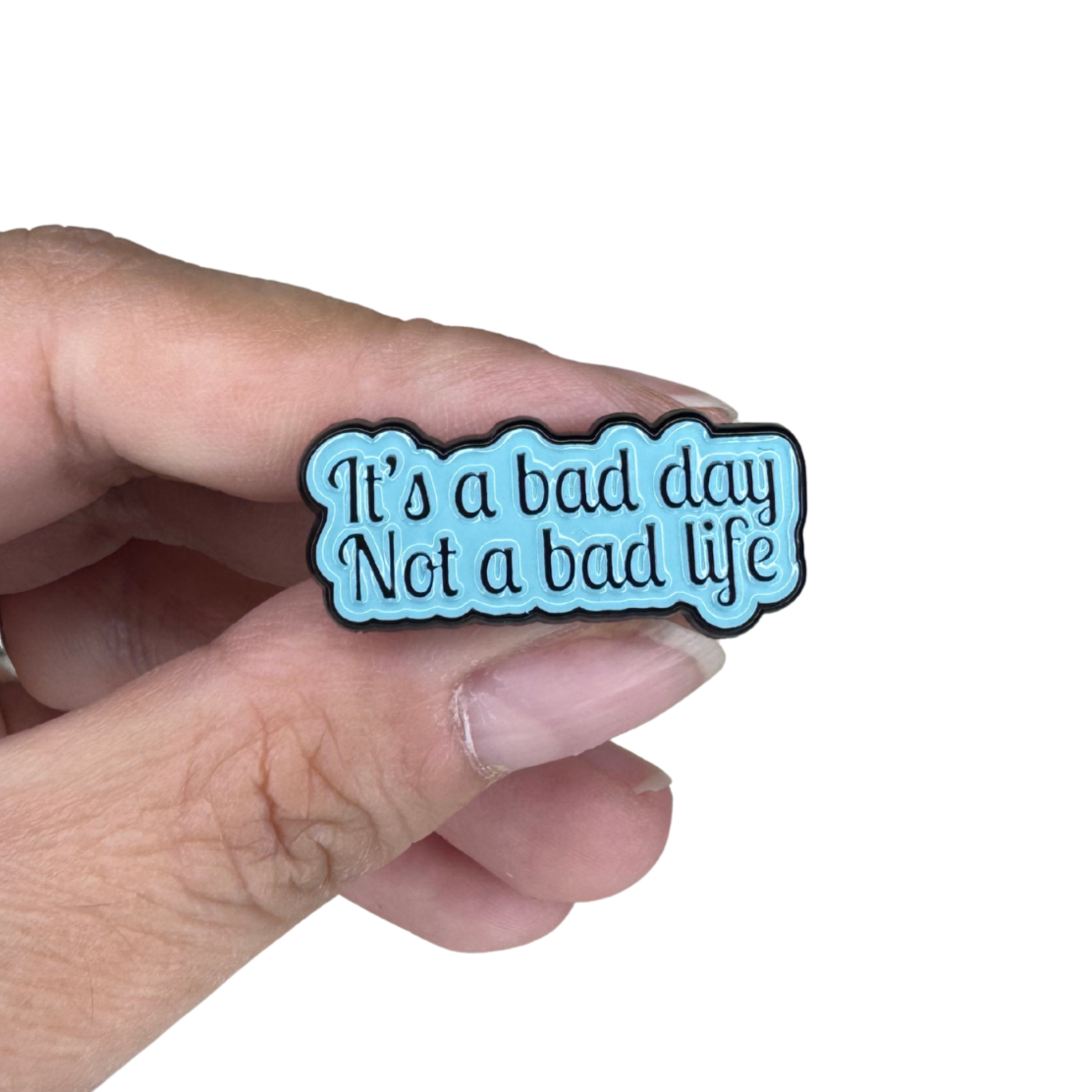 Hand holding the enamel pin for scale