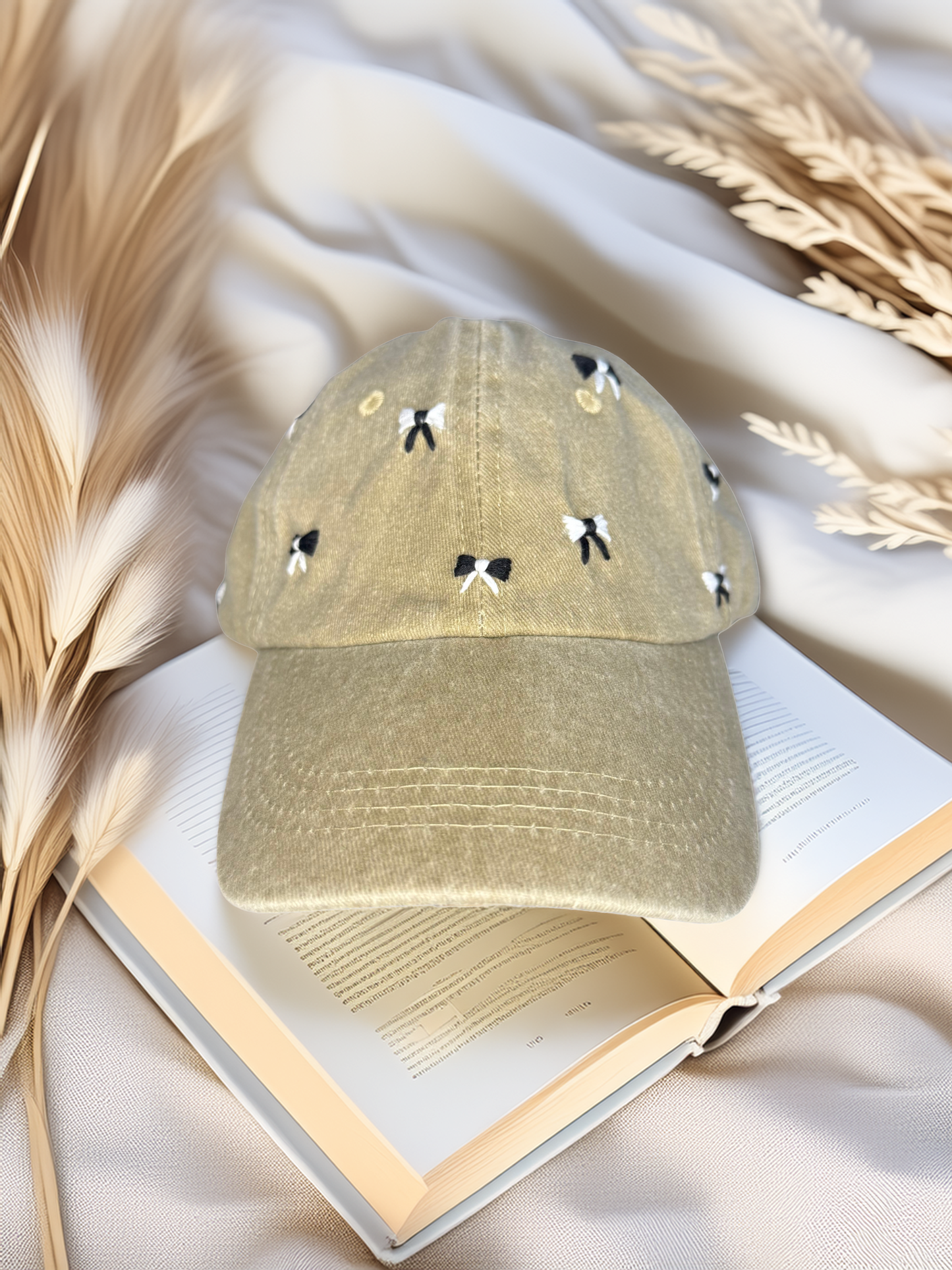 Green cap with black and white designs on an open book with feathers and wheat in the background