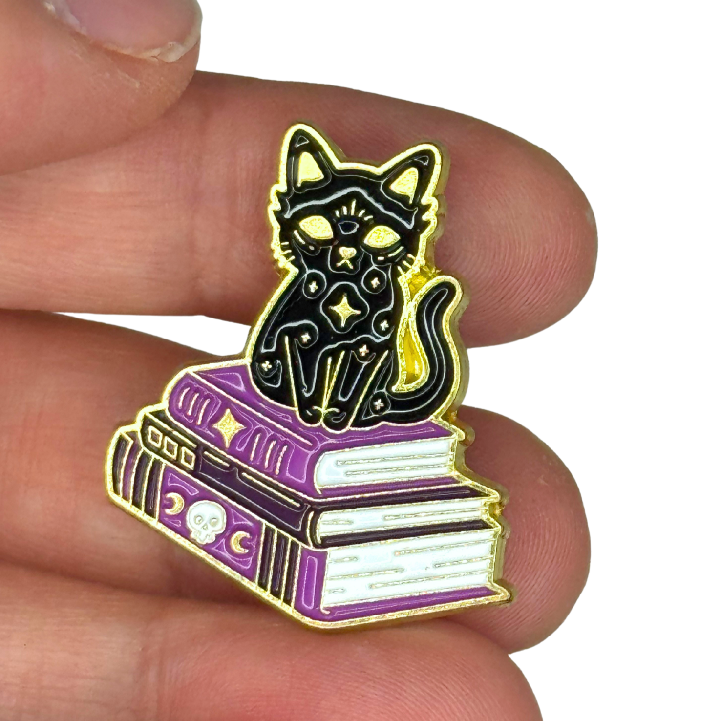 “Black cat book pin shown on fingers for size reference”