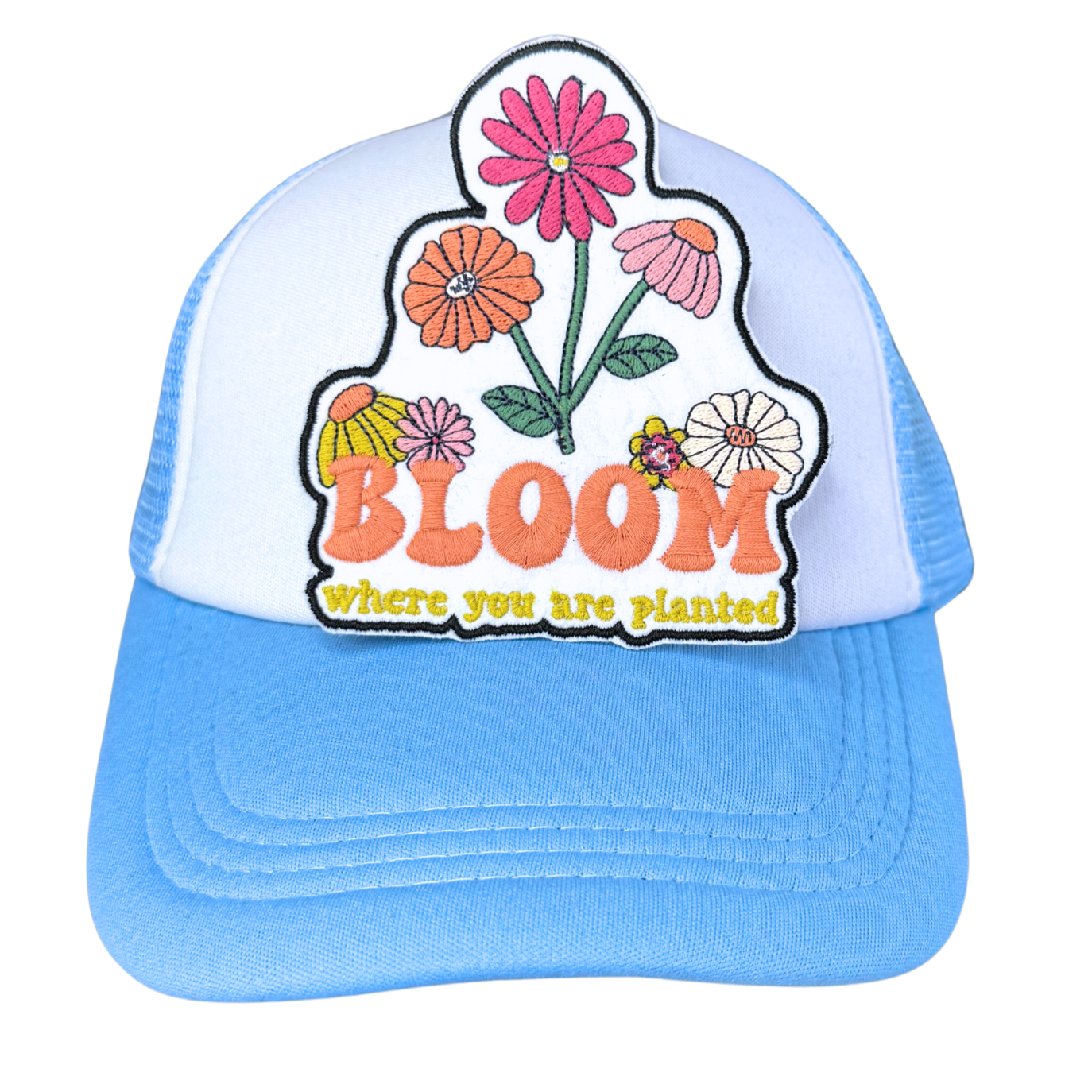"Bloom Where You Are Planted" embroidered patch attached to a light blue and white trucker hat.