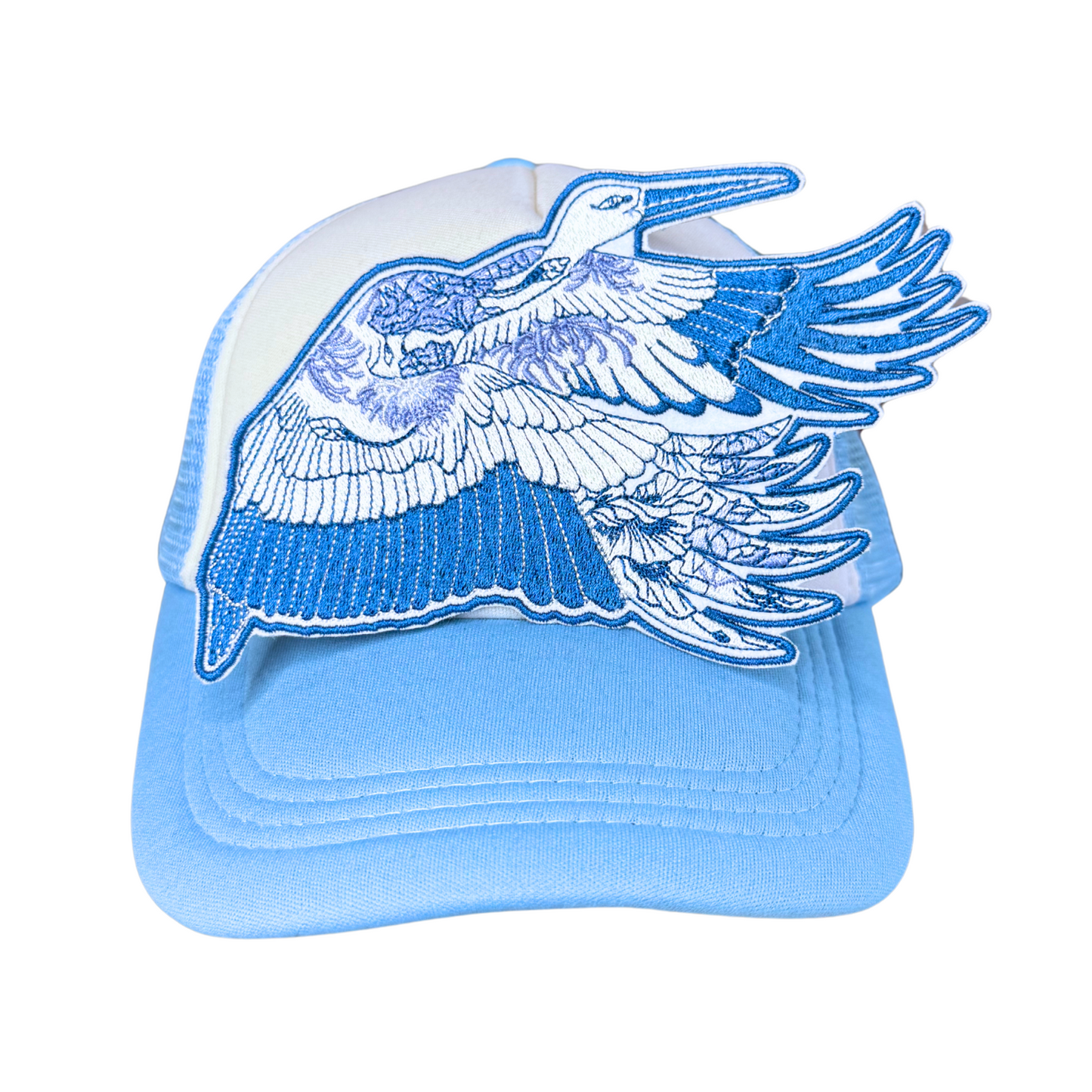 Blue heron embroidered patch attached to a light blue and white trucker hat.