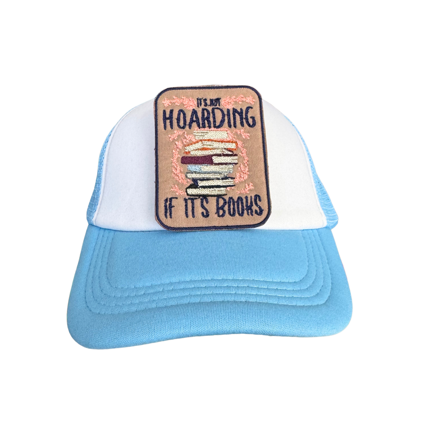 Close-up of a book lover iron-on patch applied to a blue and white trucker hat, showcasing detailed embroidery.