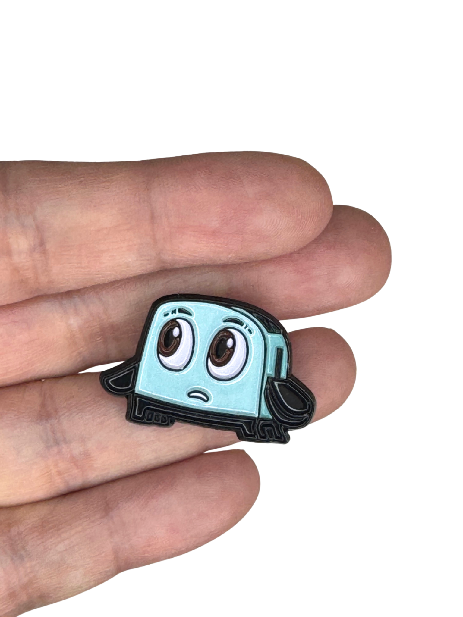 Brave Little Toaster enamel pin held in hand for size reference