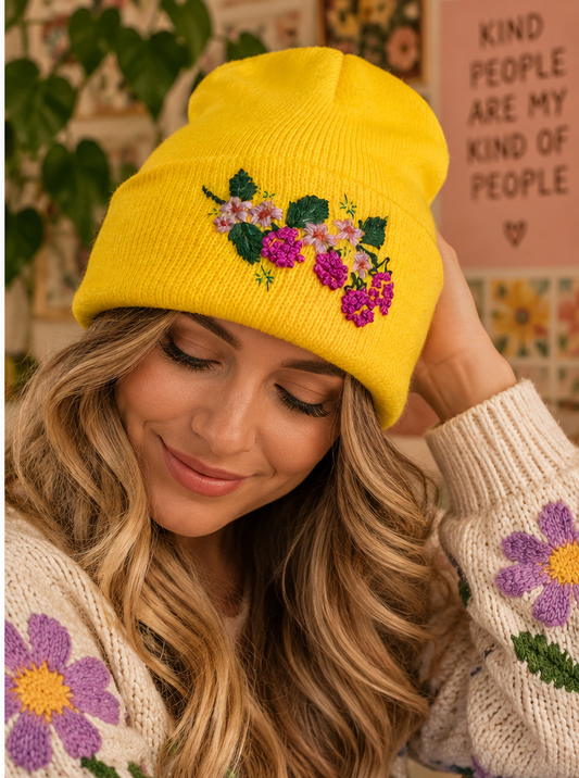 Woman wearing bright yellow hand-embroidered berry floral beanie