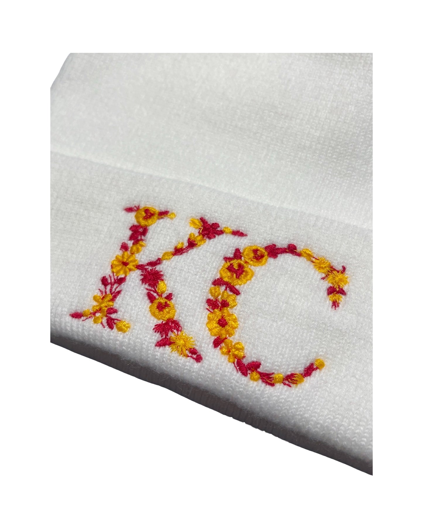 close up of embroidery letters KC in kc chiefs red and yellow flowers