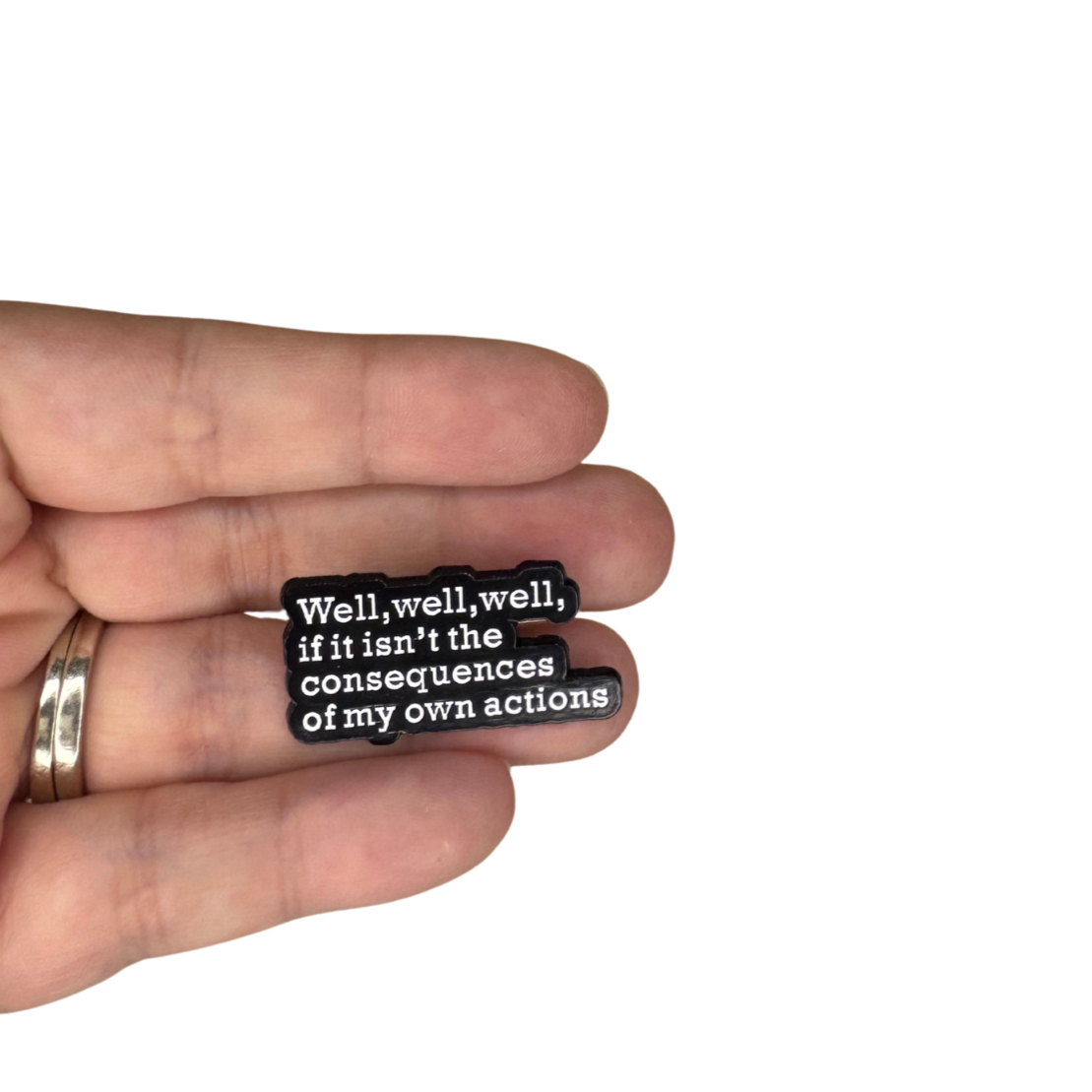 Pin shown in hand for scale