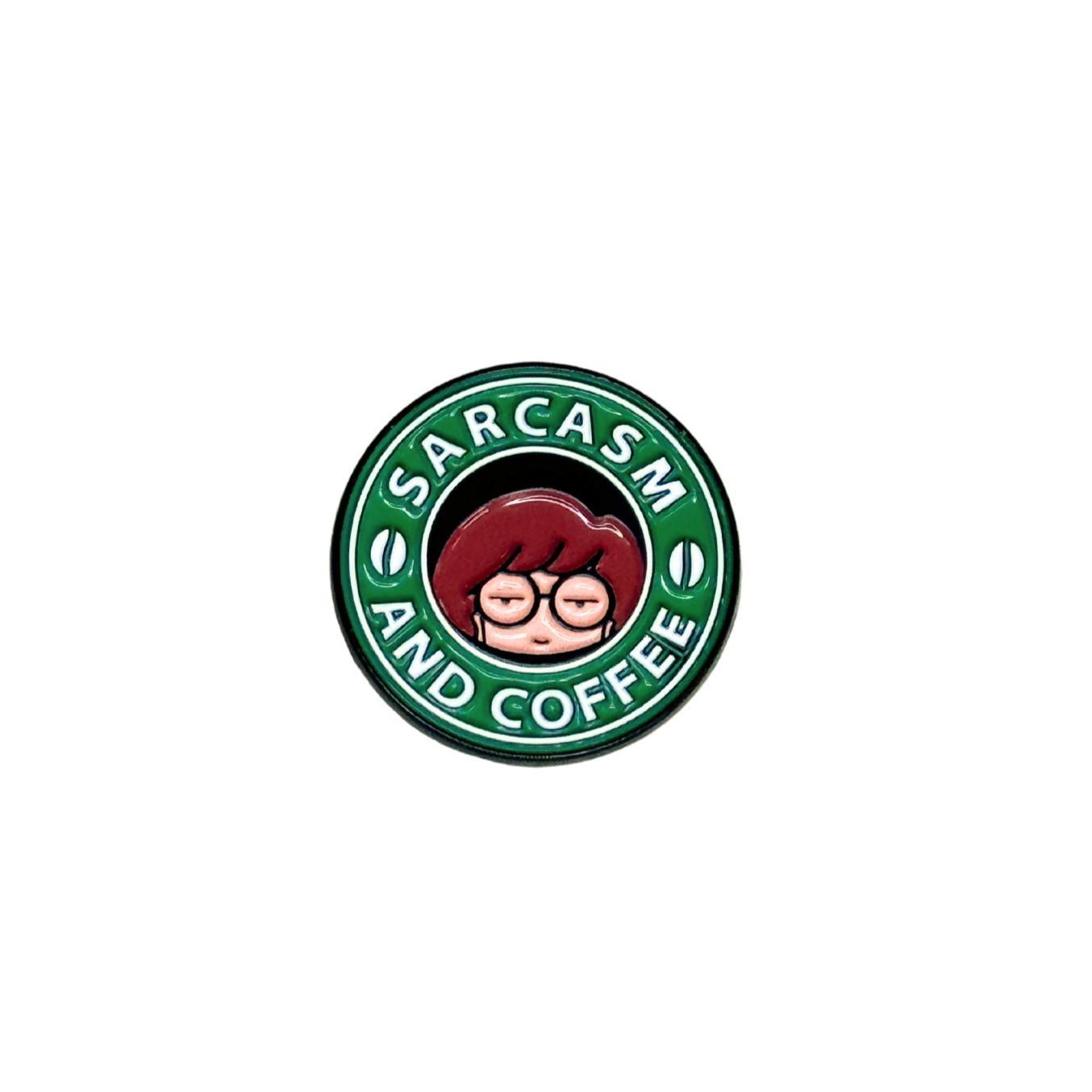 Close-up of green and black "Sarcasm and Coffee" enamel pin on white background