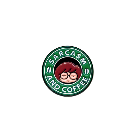 Close-up of green and black "Sarcasm and Coffee" enamel pin on white background