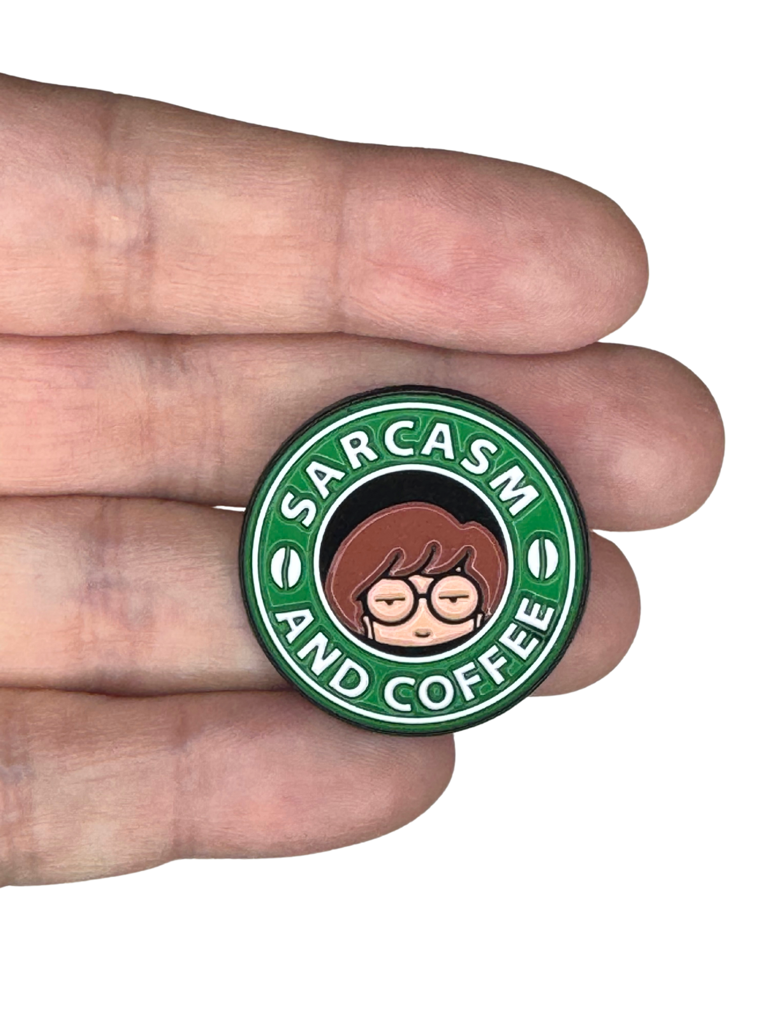 Hand holding "Sarcasm and Coffee" enamel pin to show scale