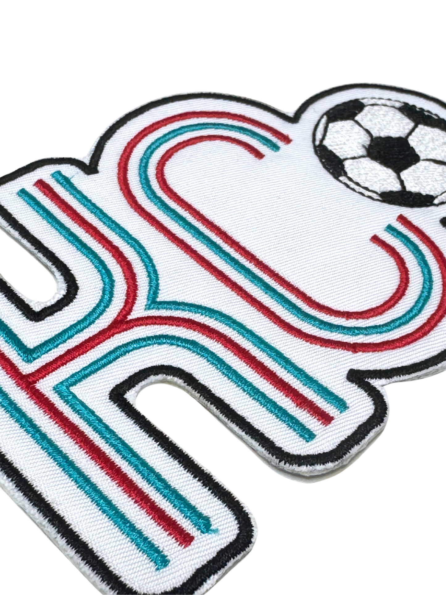 Close-up showing red and teal embroidery detail on KC soccer patch