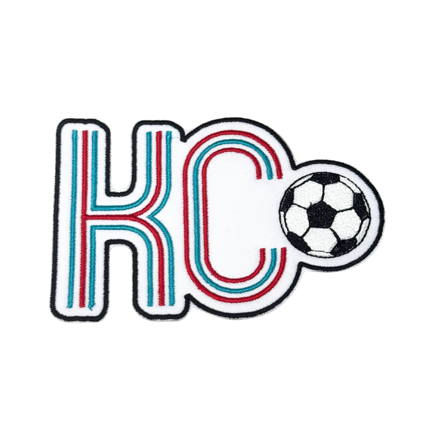 Front view of embroidered KC soccer patch on white background