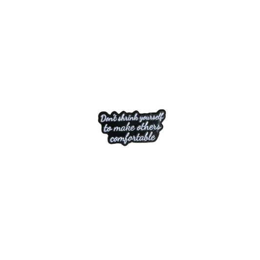 Hero image showing the "Don't shrink yourself to make others comfortable" enamel pin on white background
