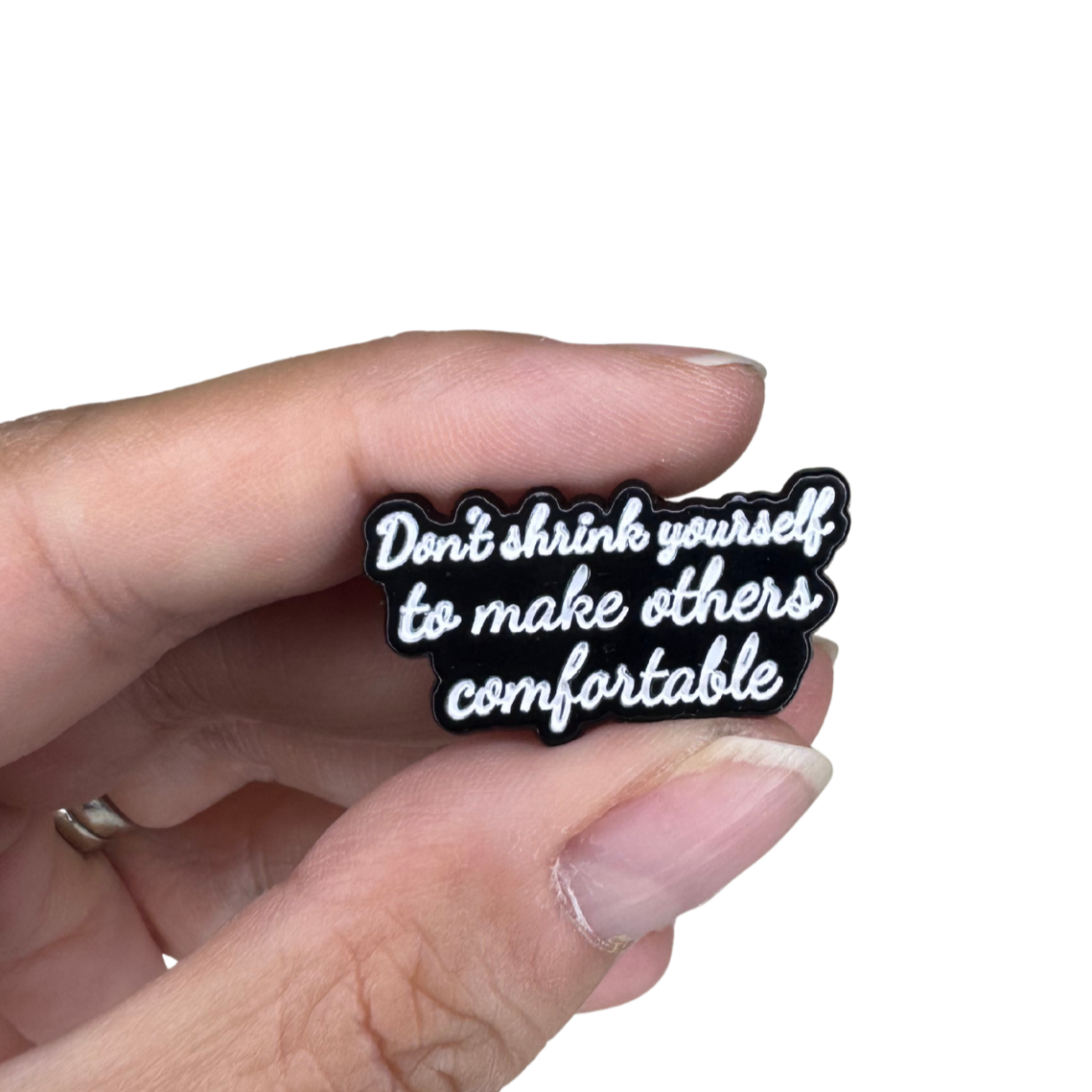 Scale image showing the pin held between fingers for size reference