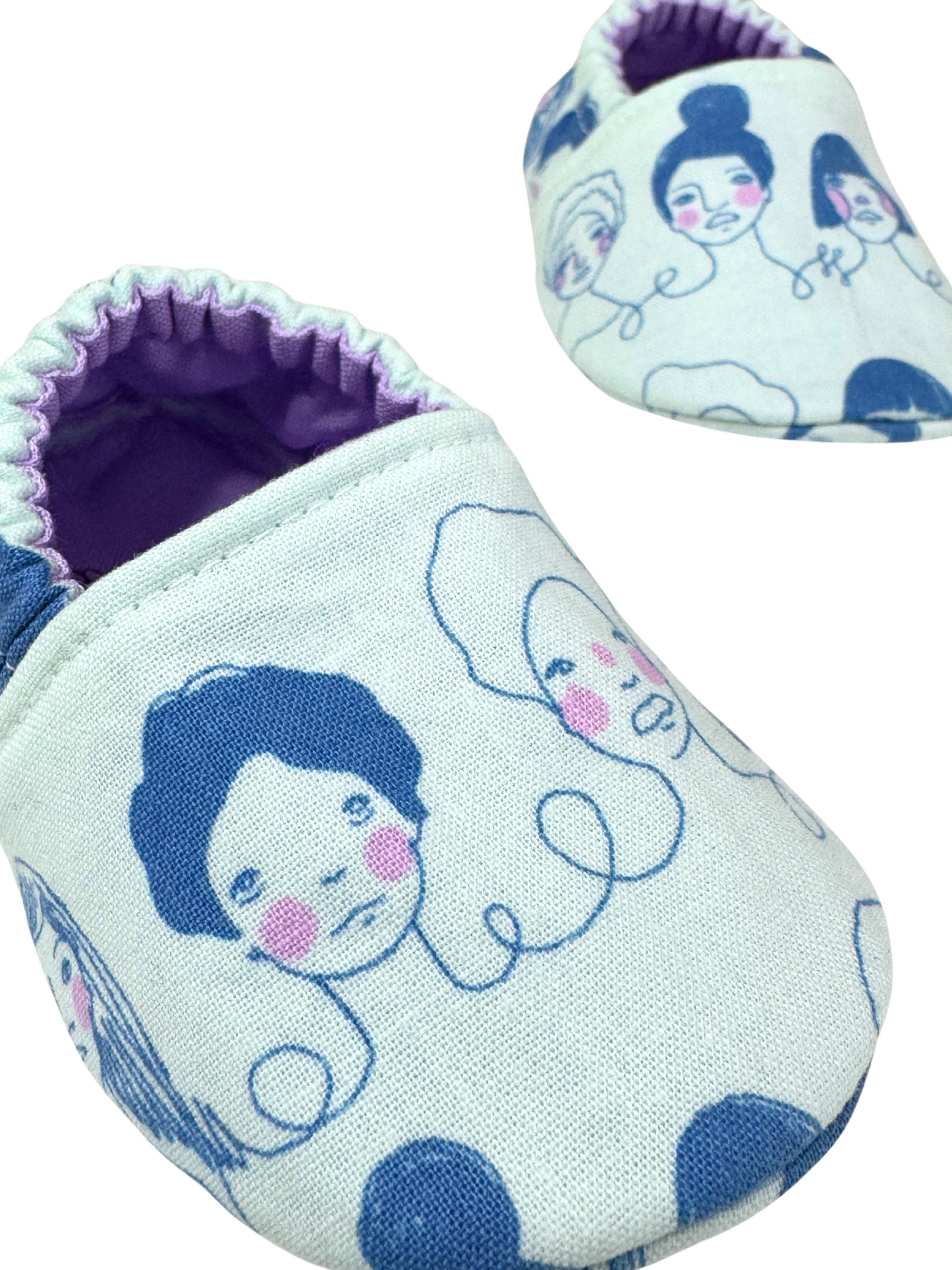“Close-up of feminist icon faces design on handmade soft sole baby moccasins, 3-6 months”