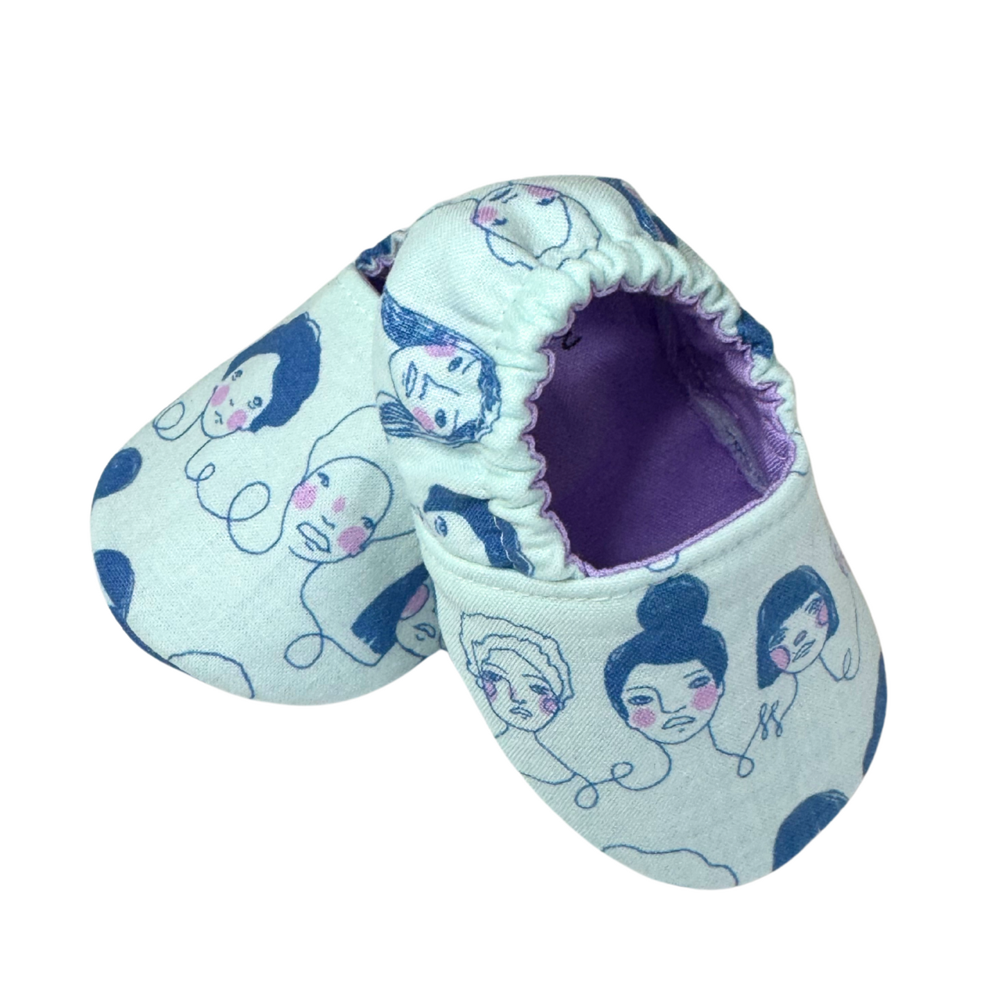 “Side view of handmade baby moccasins with feminist faces print, soft sole, 3-6 months”