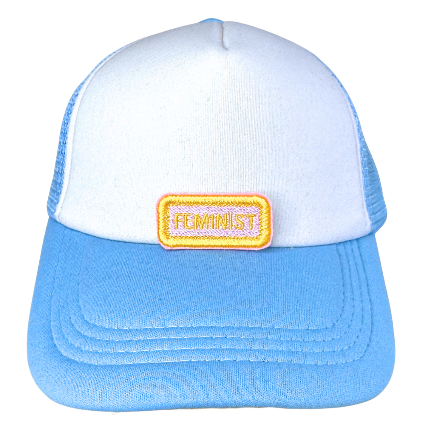 "Blue and white trucker hat featuring an embroidered feminist patch in a name tag style."