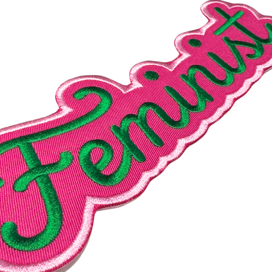 Angled close-up of Feminist patch showing satin embroidery texture