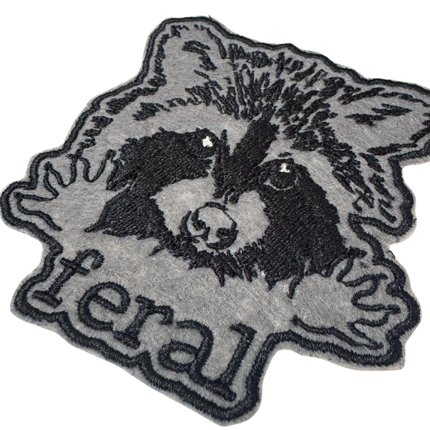 Close-up angled view of feral raccoon embroidered patch