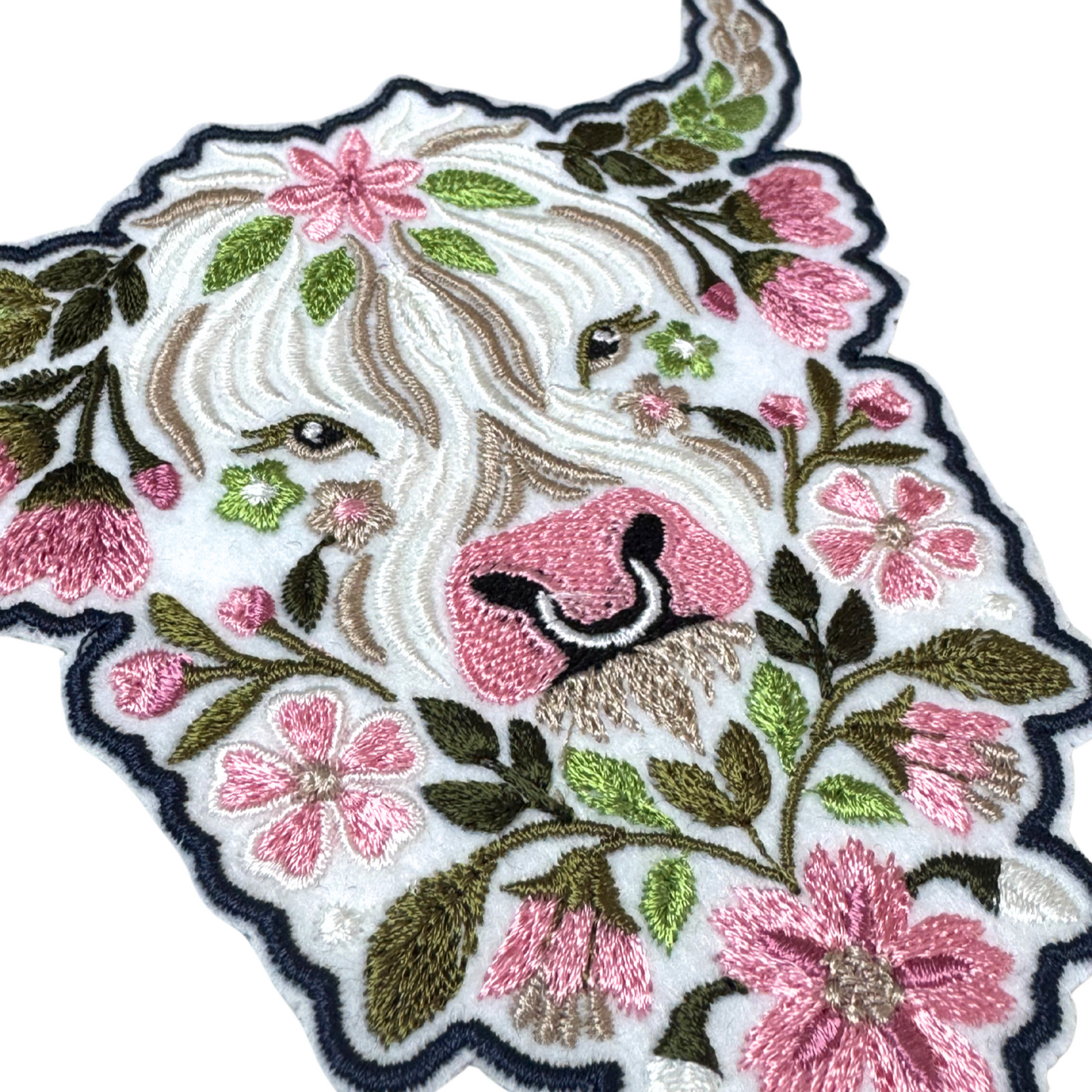 Side angle close-up of floral Highland cow embroidery details on patch