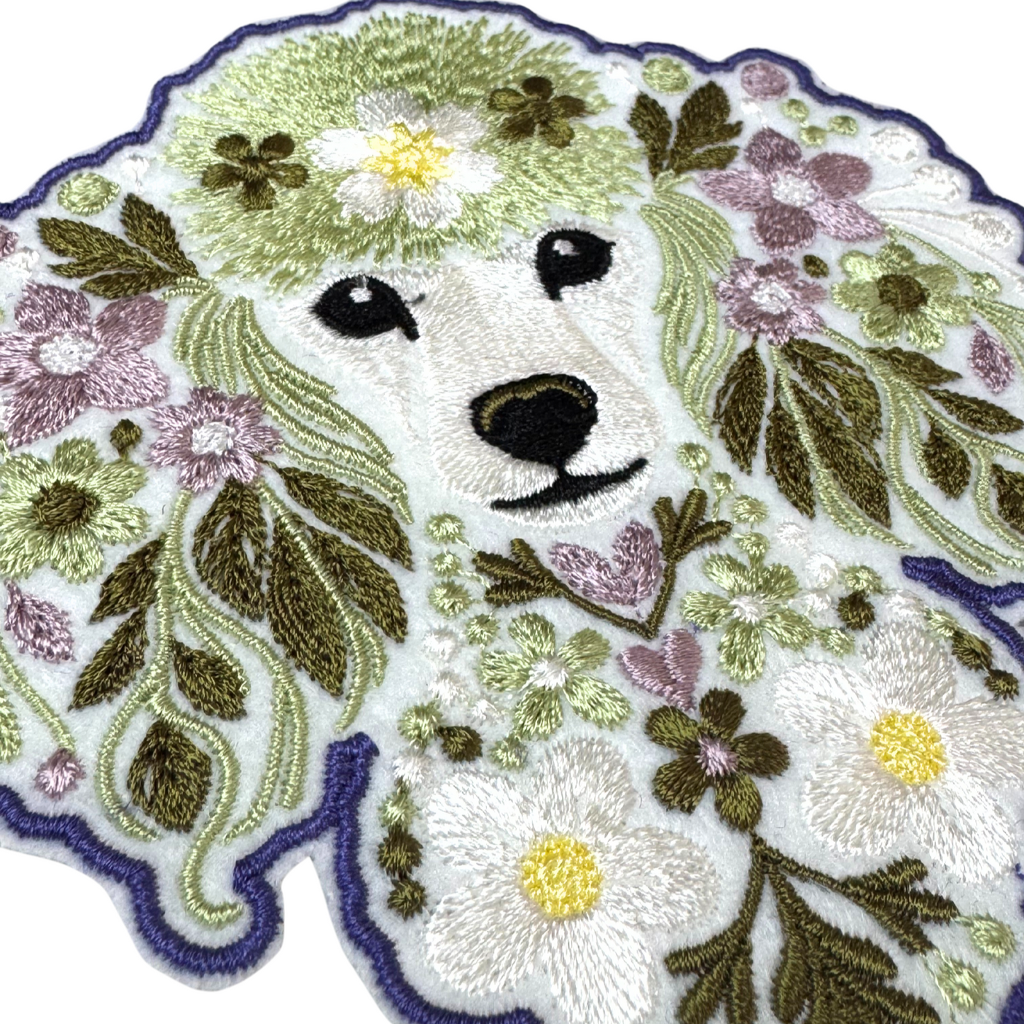 Close-up detail of floral poodle embroidery on iron-on patch