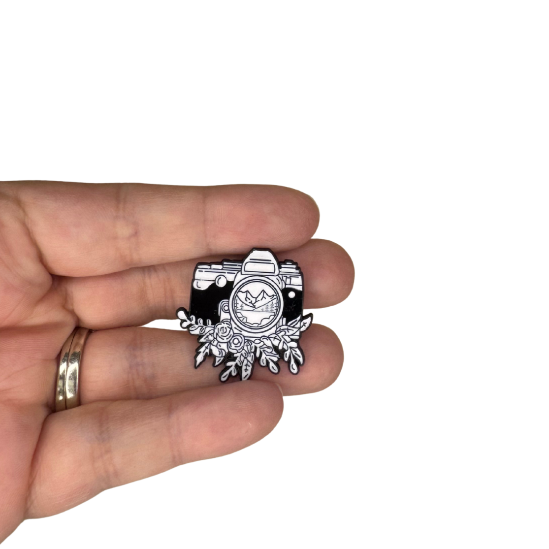 Hand holding the enamel pin for size reference