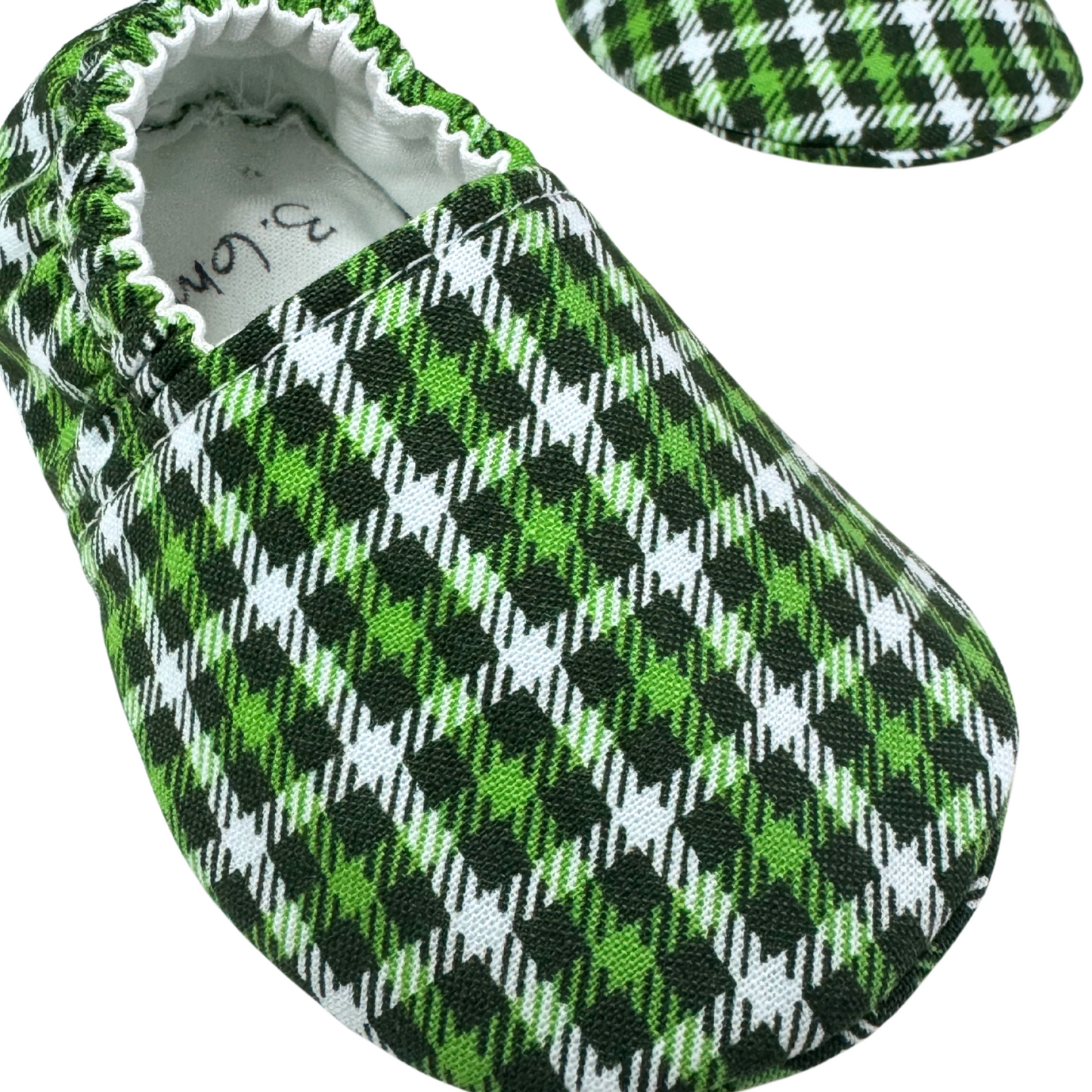 “Close-up of green plaid fabric on handmade baby moccasins, soft sole, 3-6 months”