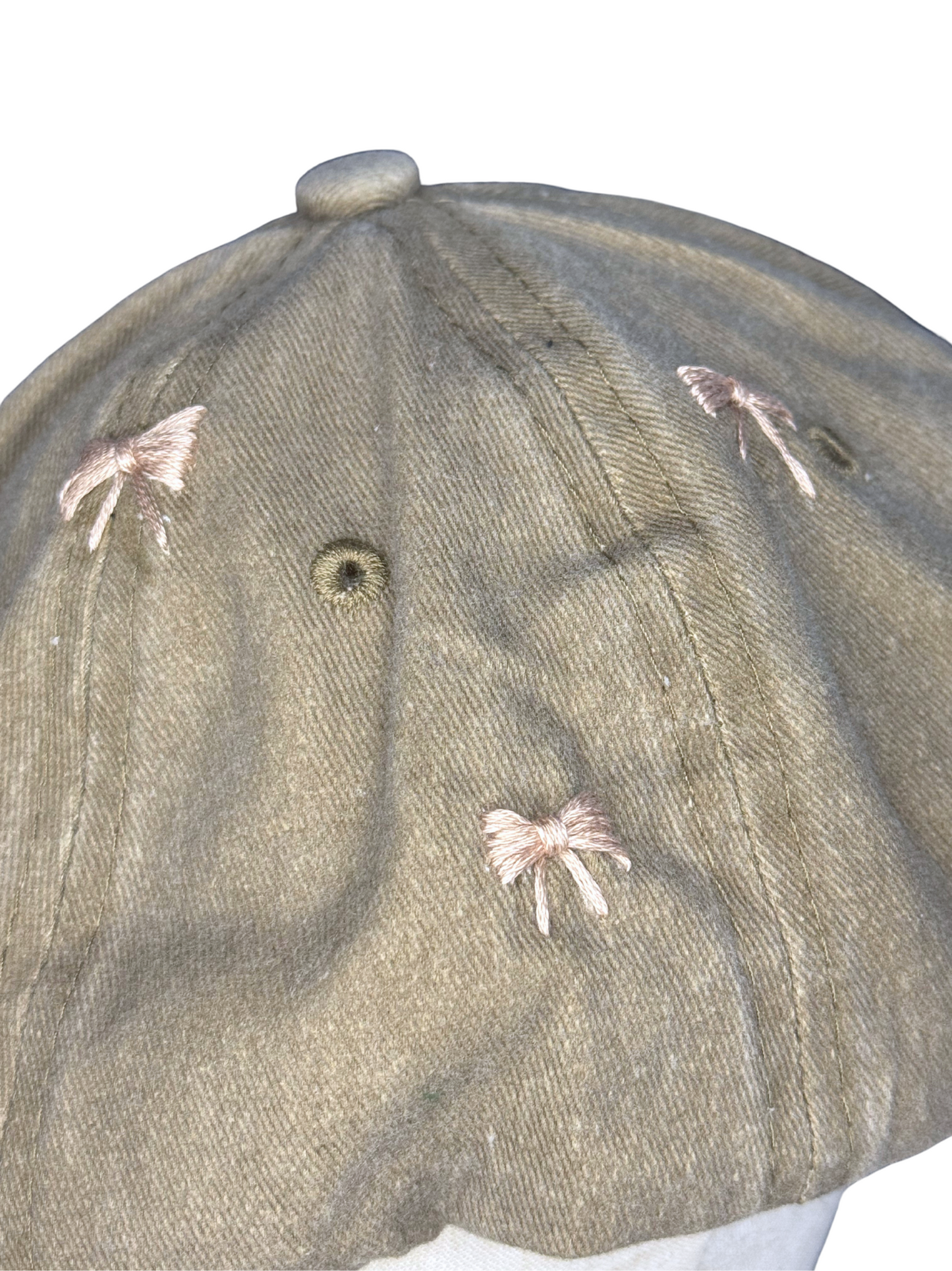 Close-up of a cap with bow embroidery on a white background
