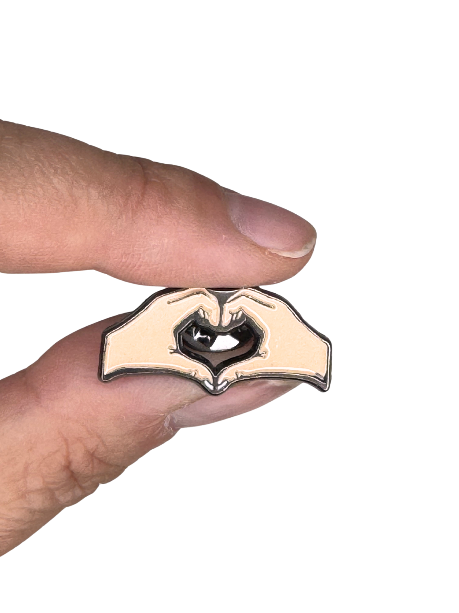 Minimalist heart hand pin held between fingers